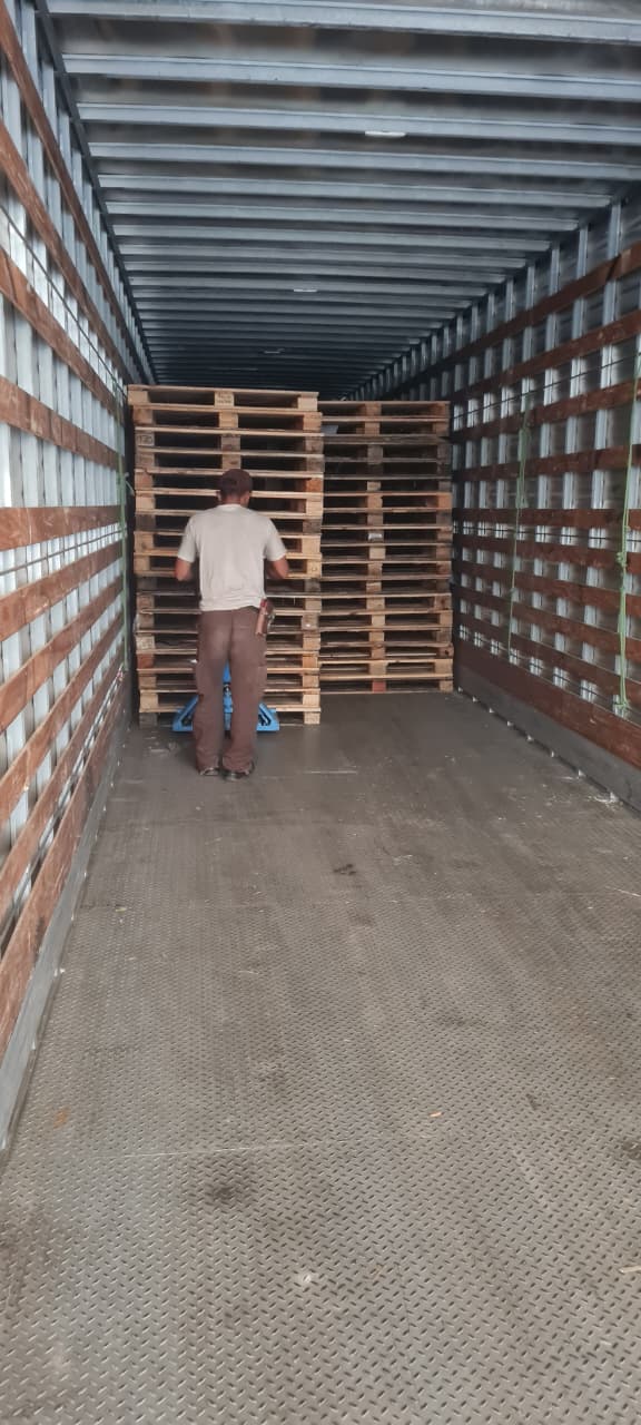 Trabalhador organizando pallets dentro de um caminhão